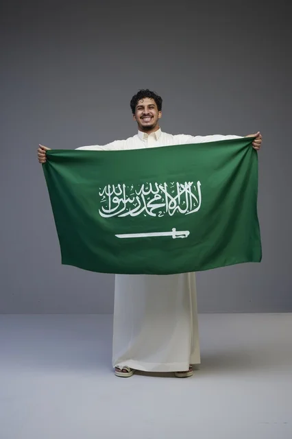 رجل سعودي يحمل علم المملكة العربية السعودية