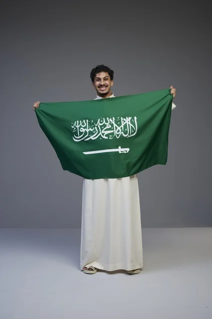 رجل سعودي يحمل علم المملكة العربية السعودية