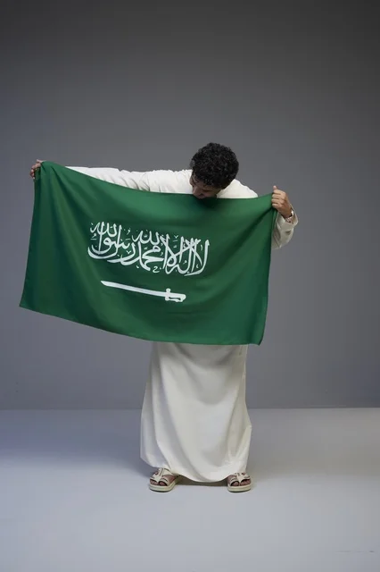 Saudi Man Holding National Flag in Studio Portrait