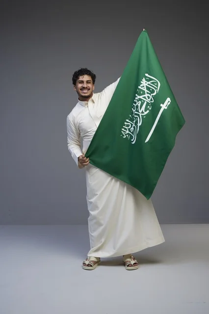 رجل سعودي يحمل علم المملكة العربية السعودية