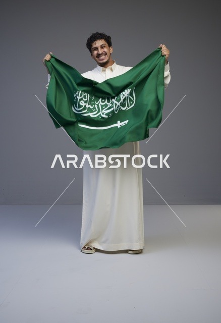 رجل سعودي يحمل علم المملكة العربية السعودية