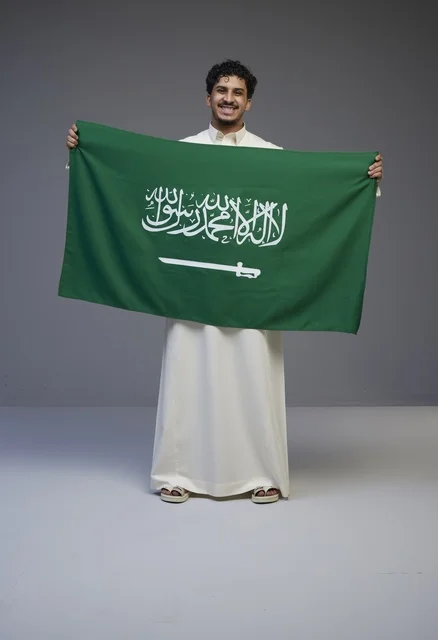 Saudi Man Holding Saudi Arabia Flag in Studio Portrait