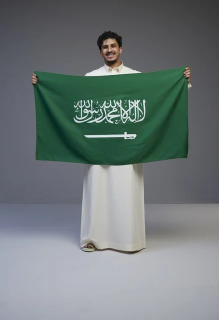 Saudi Man Holding KSA National Flag in White Thobe