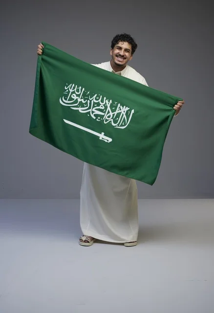 Saudi Man in Traditional Thobe Holding Saudi Arabia Flag