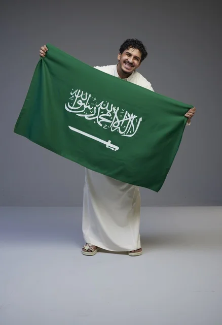 رجل سعودي يحمل علم المملكة العربية السعودية