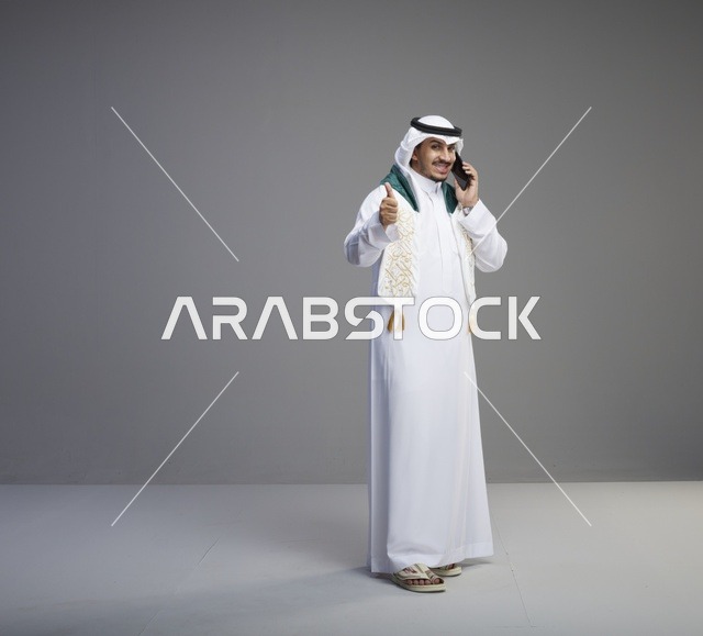 خريج سعودي يتحدث بالهاتف الذكي في استوديو