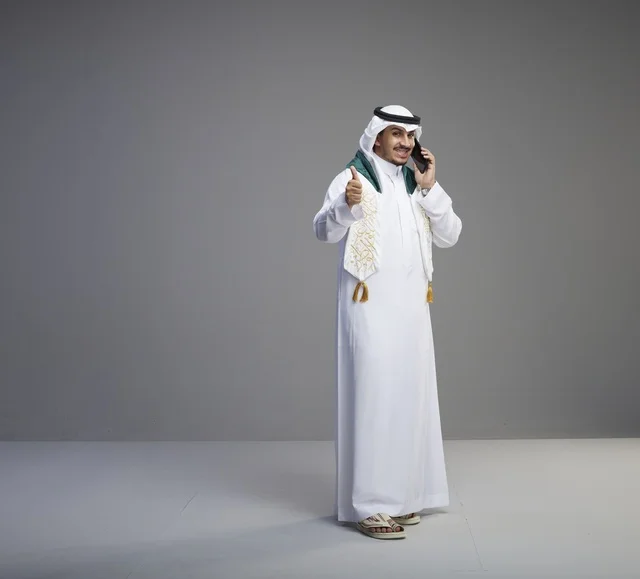 خريج سعودي يتحدث بالهاتف الذكي في استوديو