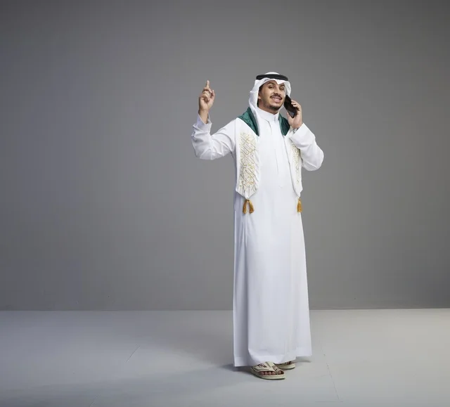خريج سعودي يتحدث عبر الهاتف الذكي في الاستوديو