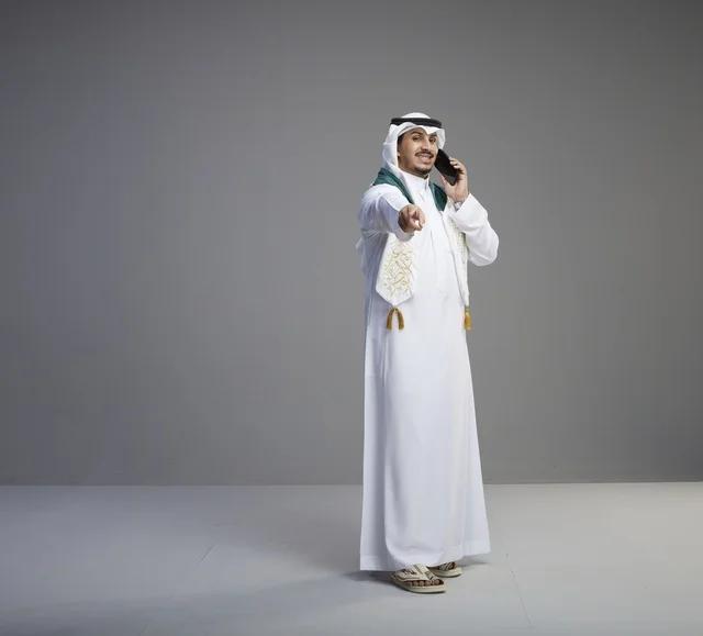 Saudi Graduate on Smartphone Pointing at Camera