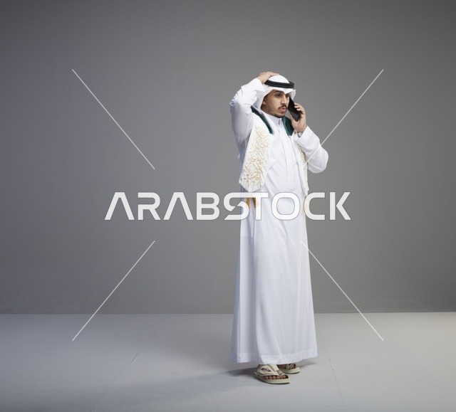 خريج سعودي بالثوب يتحدث عبر الهاتف الذكي