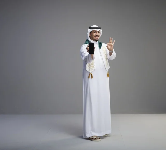 Saudi Graduate Holding Smartphone with OK Hand Gesture