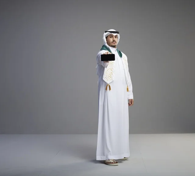 Saudi Graduate Holding Smartphone Screen in Studio