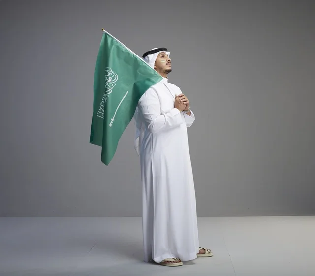 رجل سعودي يحمل العلم الوطني في الاستوديو