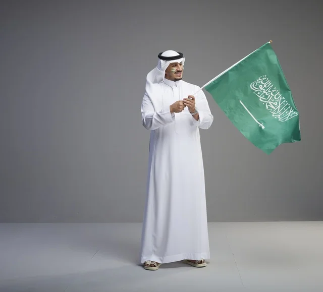 Saudi Man Holding KSA National Flag in Studio