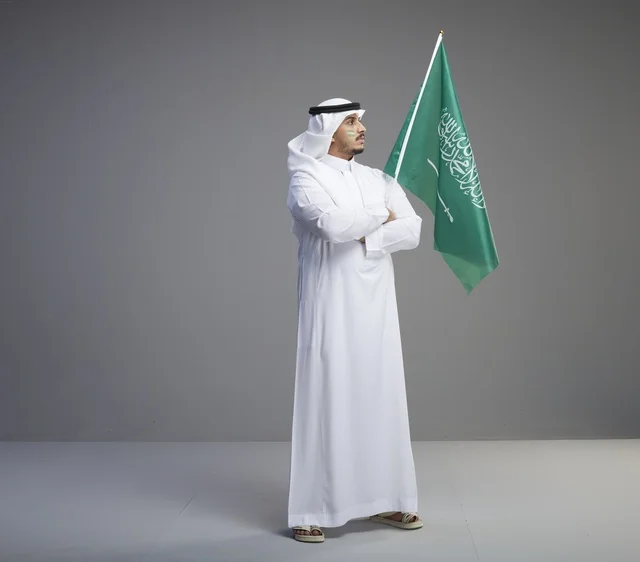 Saudi Man in Traditional Thobe with National Flag