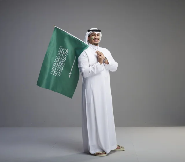 Saudi Man Holding National Flag in Studio