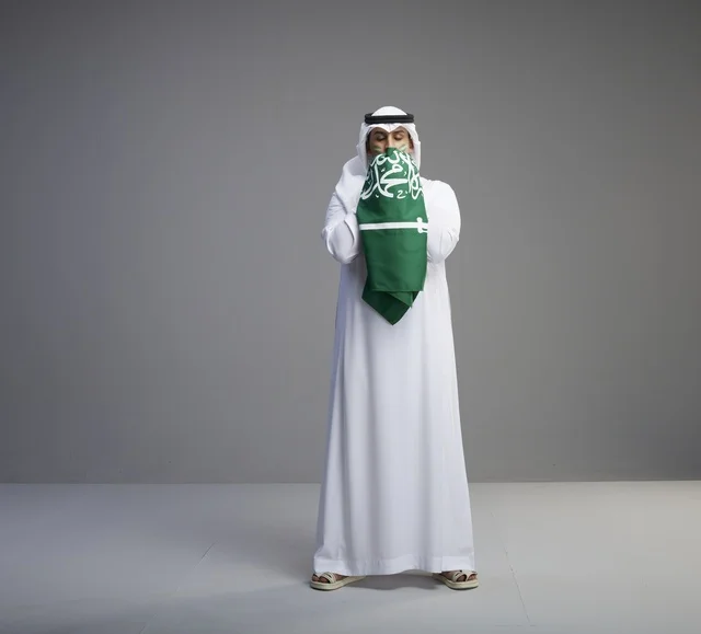 رجل سعودي يعبر عن الوطنية بتقبيل العلم في اليوم الوطني