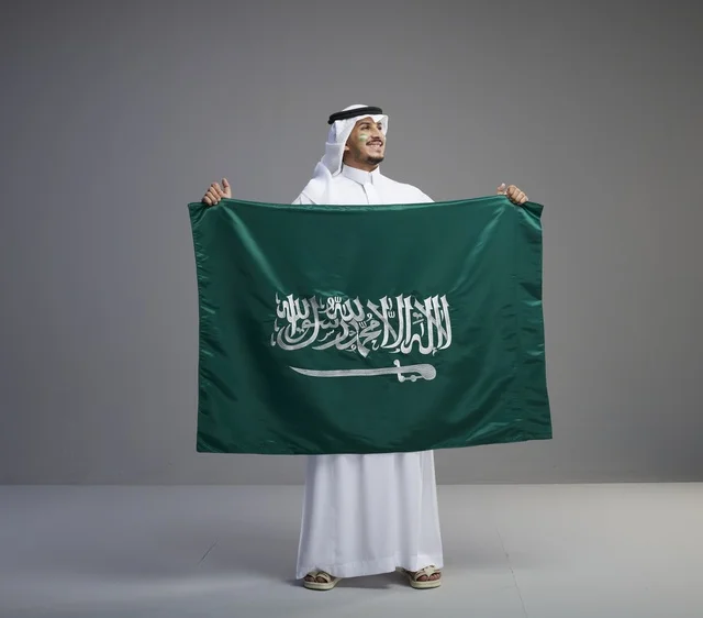 Saudi Man Holding National Flag in Studio