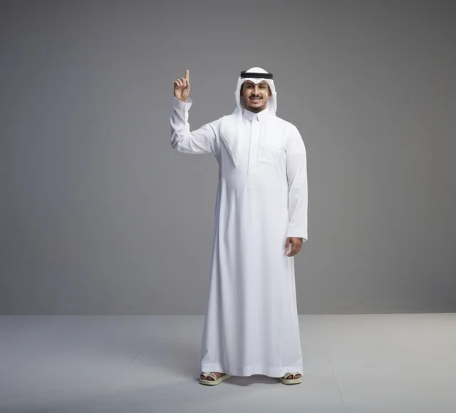 رجل سعودي بالثوب التقليدي يشير للأعلى في الاستوديو