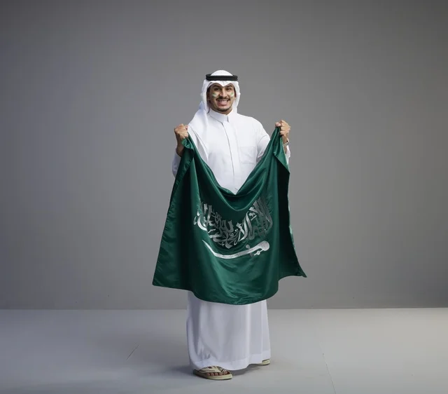 Saudi Man Holding Saudi Arabia National Flag in Studio