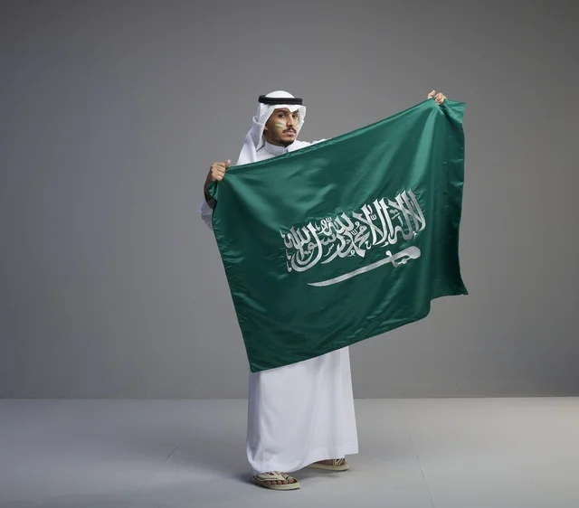 رجل سعودي يحمل العلم الوطني السعودي