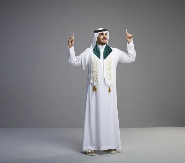 Saudi Graduate Man in Traditional Attire Pointing Up