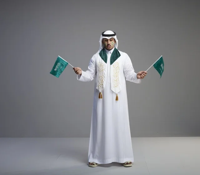 رجل سعودي يحمل الأعلام الوطنية للاحتفال رجل سعودي يحمل الأعلام الوطنية للاحتفال