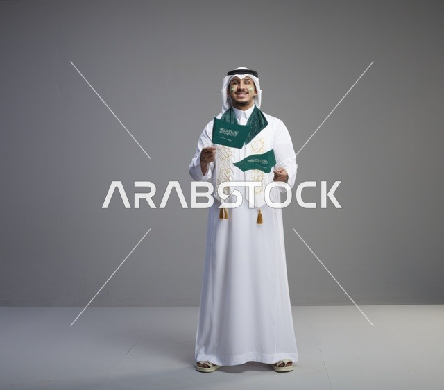 رجل سعودي يحمل الأعلام الوطنية احتفالاً باليوم الوطني