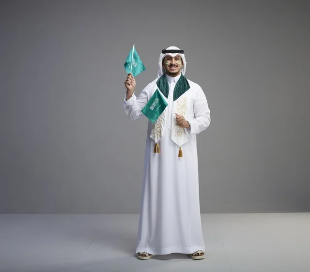 رجل سعودي يحمل الأعلام الوطنية للاحتفال