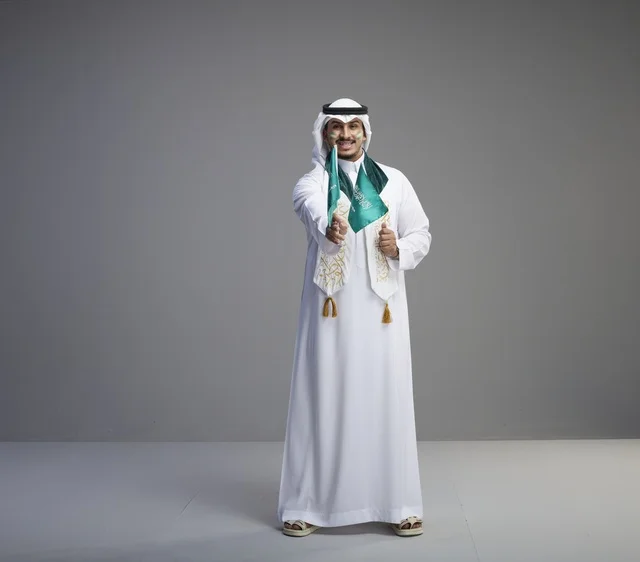 رجل سعودي يحمل الأعلام الوطنية في الاستوديو