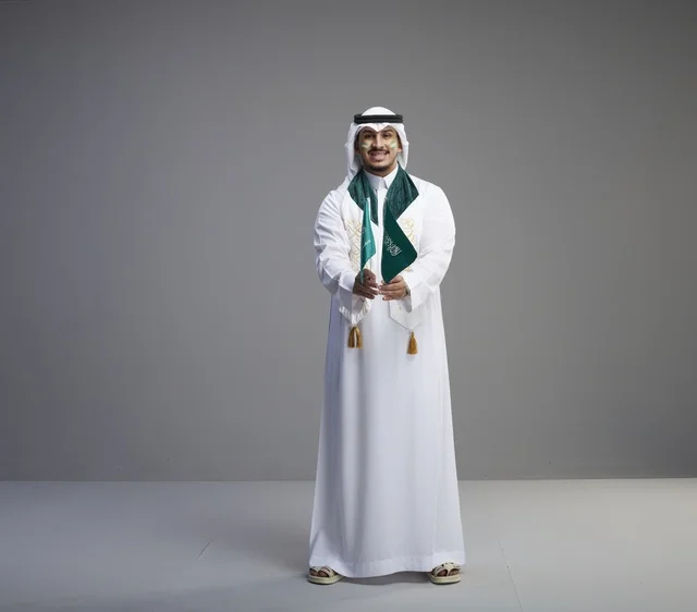 Saudi Man in Traditional Thobe Holding National Flag