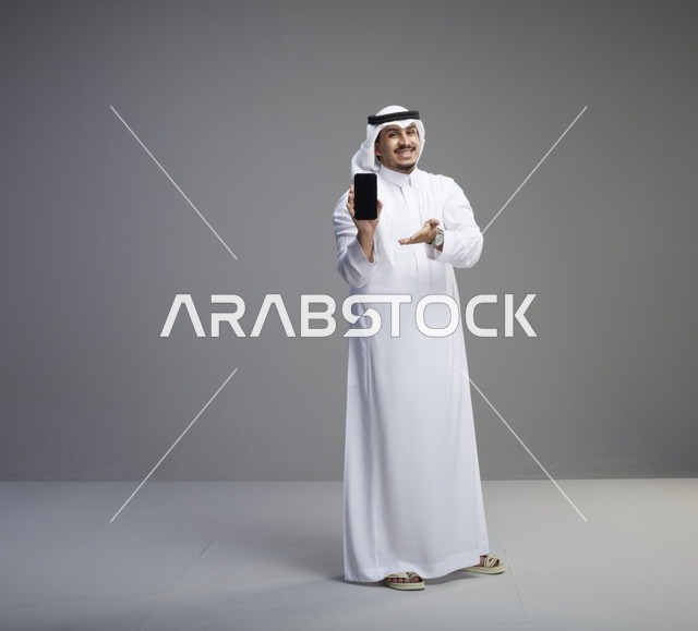 رجل سعودي يحمل هاتف ذكي بشاشة سوداء فارغة