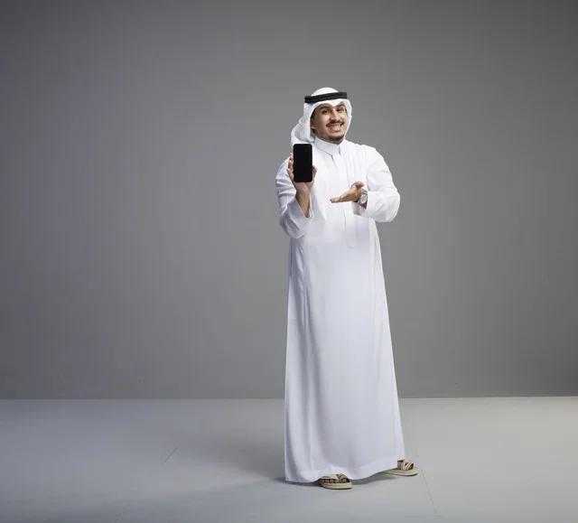 رجل سعودي يحمل هاتف ذكي بشاشة سوداء فارغة
