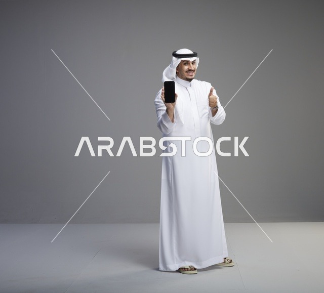 رجل سعودي يحمل هاتف ذكي بشاشة فارغة