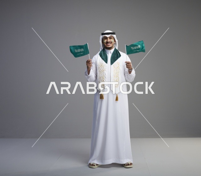 رجل سعودي يحمل الأعلام في احتفال اليوم الوطني