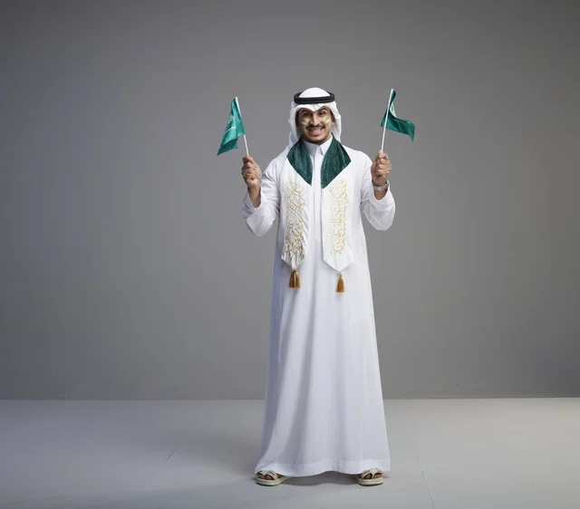 رجل سعودي يحمل الأعلام الوطنية للاحتفال