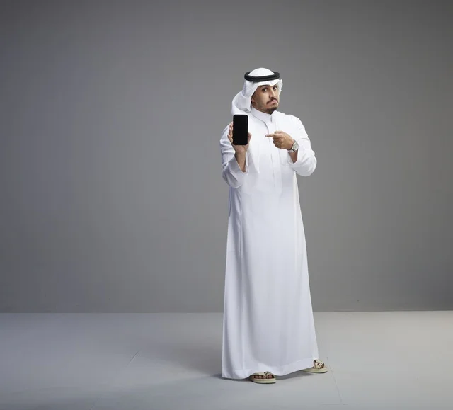 Saudi Man Holding Blank Smartphone Screen Grey Background