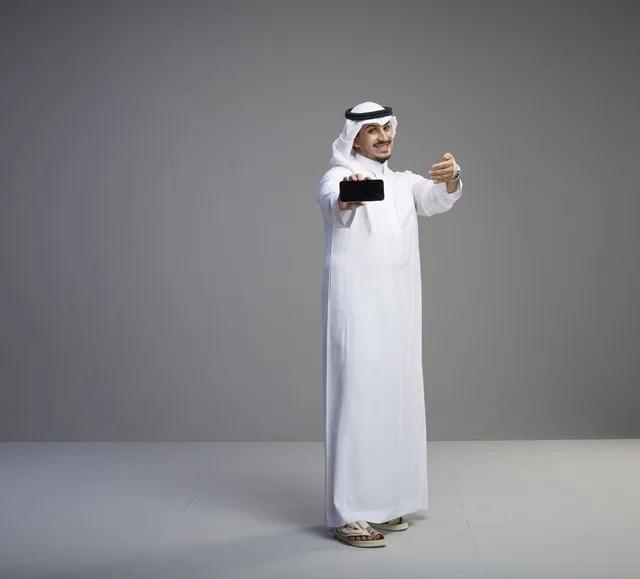 Saudi Man Holding Smartphone with Blank Screen