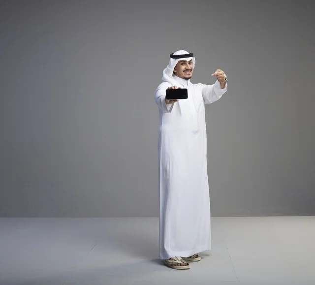 Saudi Man Holding Blank Smartphone Screen in Studio