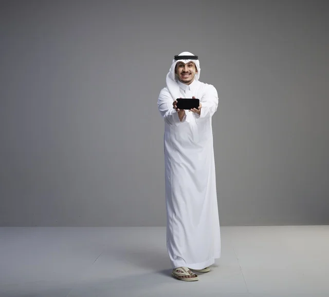 Saudi Man Holding Blank Smartphone Screen in Studio