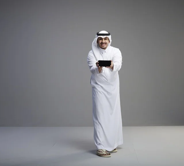 Saudi Man Holding Blank Smartphone Screen in Studio