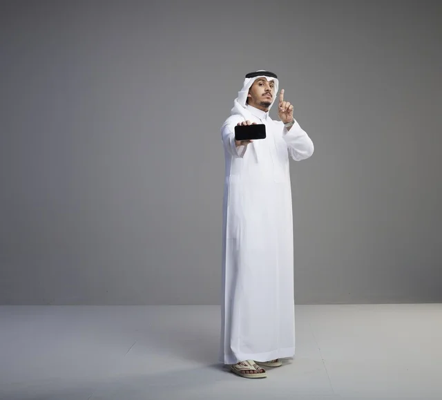 Saudi Man Holding Blank Smartphone Screen in Studio