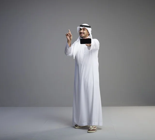 رجل سعودي يحمل هاتف ذكي بشاشة فارغة