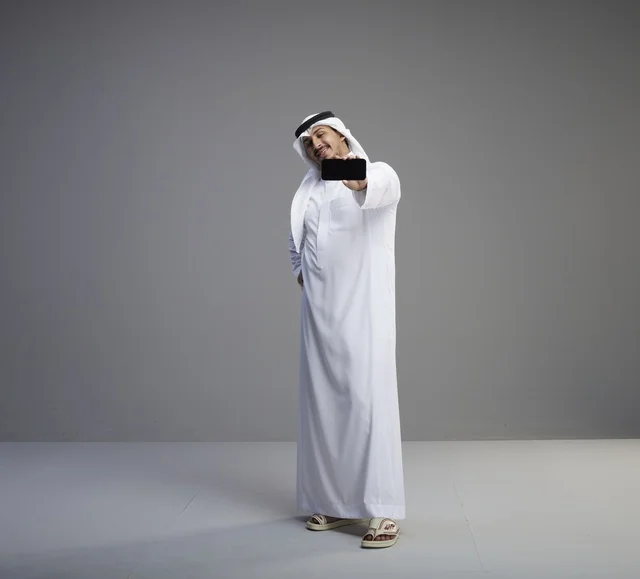 Saudi Man Holding Blank Smartphone Screen in Studio