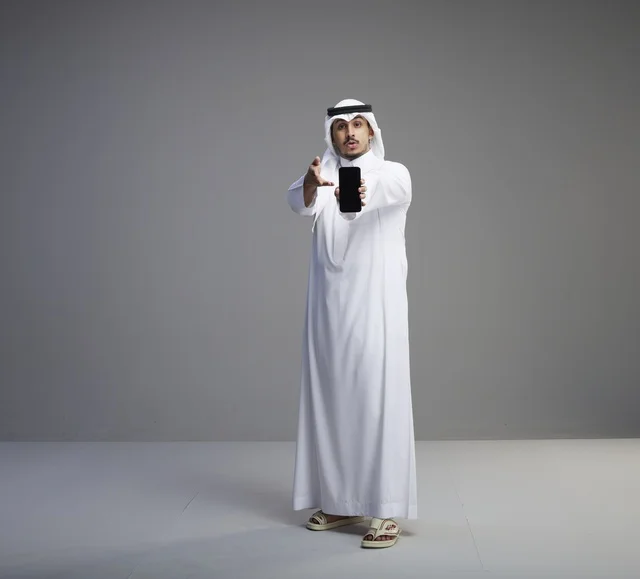Saudi Man Holding Blank Smartphone Screen in Studio