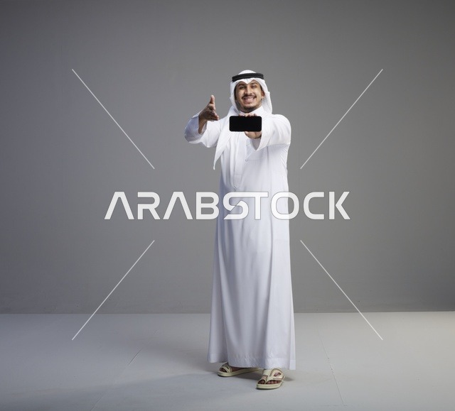 رجل سعودي يحمل هاتف ذكي بشاشة فارغة