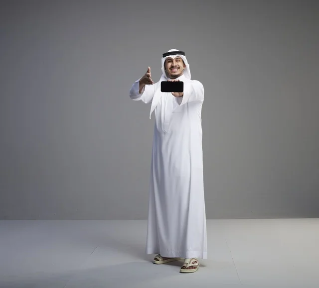 رجل سعودي يحمل هاتف ذكي بشاشة فارغة