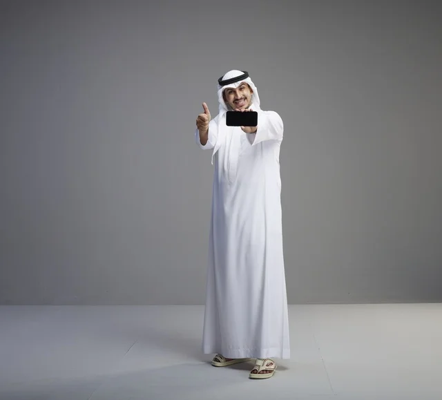 رجل سعودي يحمل هاتف ذكي بشاشة فارغة رجل سعودي يحمل هاتف ذكي بشاشة فارغة