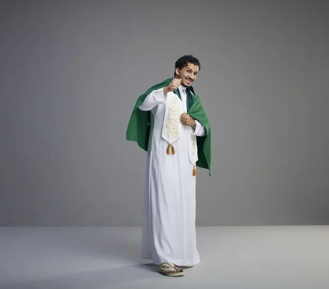 Saudi Man Wearing National Flag on Grey Background Studio