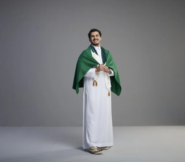Saudi Man with National Flag on Gray Background